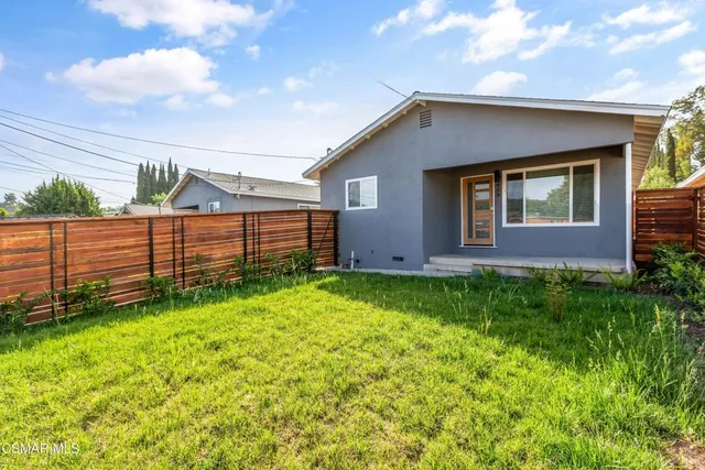 a view of backyard of house with green space