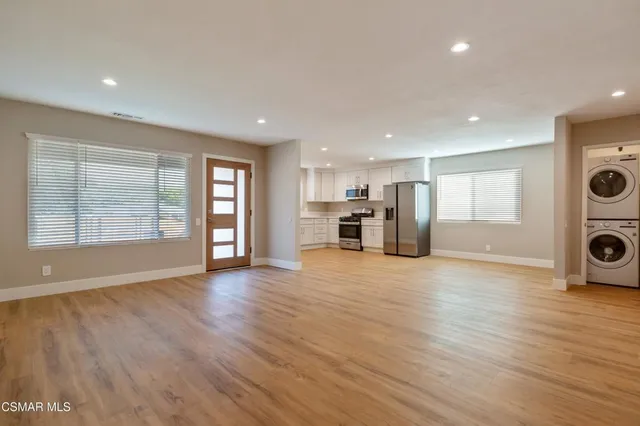 a view of a big room with wooden floor and windows