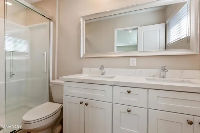 a bathroom with a toilet a sink a vanity and mirror