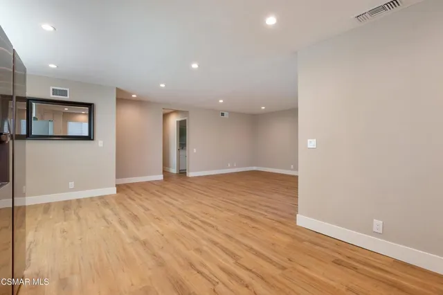 an empty room with wooden floor and entrance
