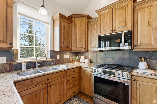 3026 Lower Saddleback Road Park City, UT 84098 - Photo 15 of 71 Kitchen with appliances with stainless steel finishes, light stone countertops, backsplash, and vaulted ceiling