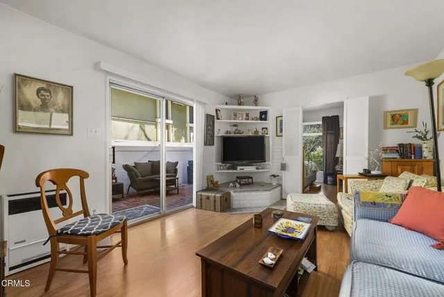 a living room with furniture a flat screen tv and wooden floor