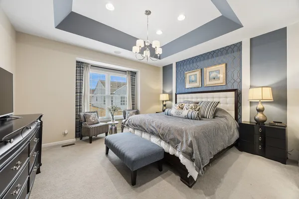 a spacious bedroom with a bed and a chandelier