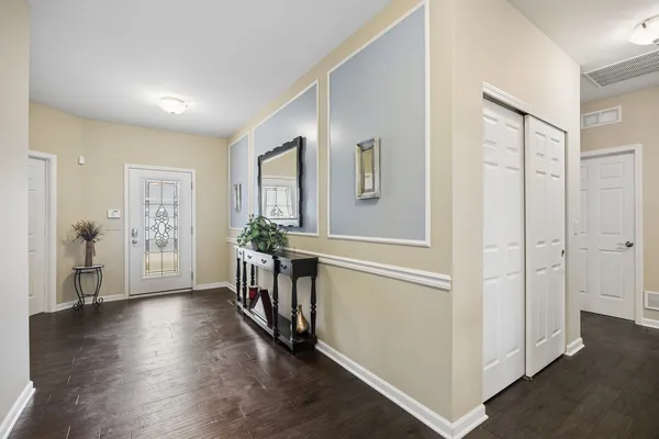 a view of a hallway with wooden floor and a bathroom