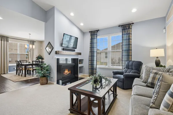 a living room with furniture a fireplace and a large window