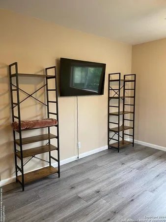 a view of a livingroom with wooden floor and a flat screen tv