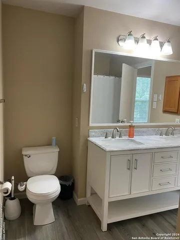 a bathroom with a toilet sink and mirror