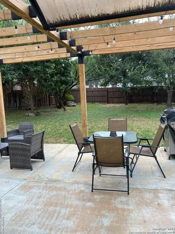 a view of a patio with lawn chairs floor to ceiling window and yard