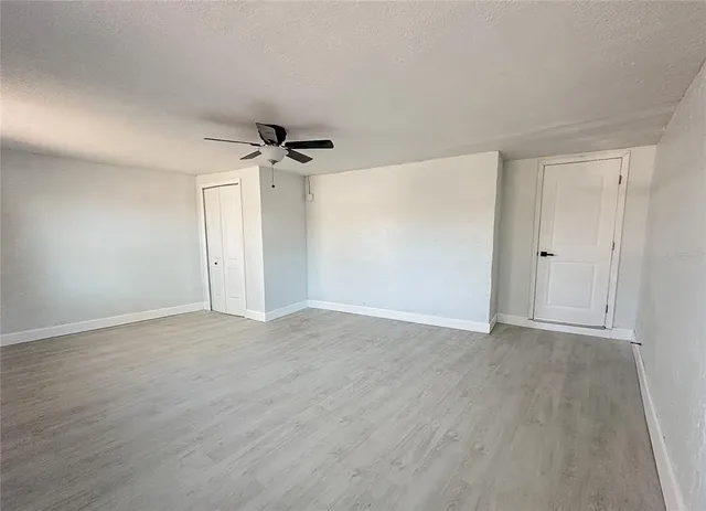 an empty room with windows and closet