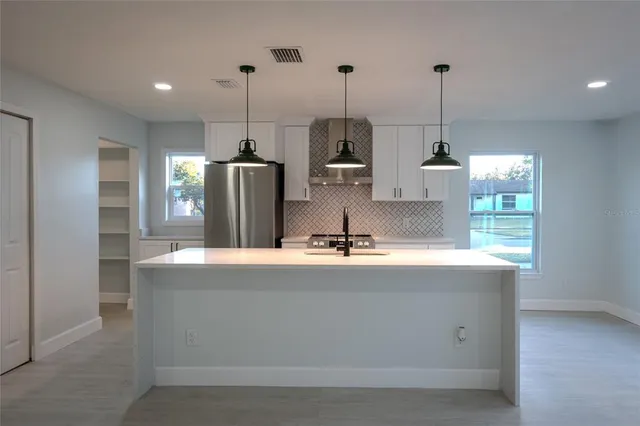 a view of kitchen with refrigerator and window