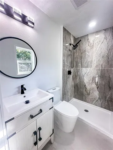 a bathroom with a toilet and a mirror