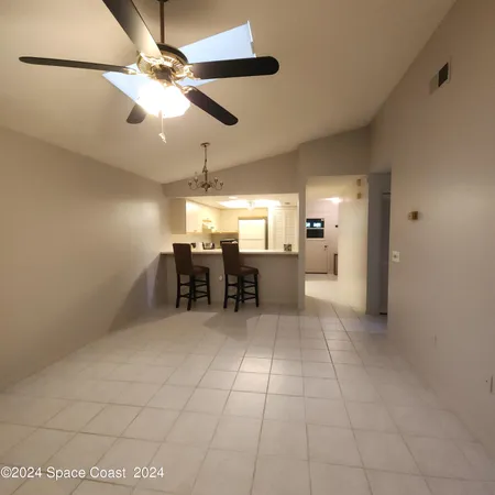 an empty room with a fan & a window