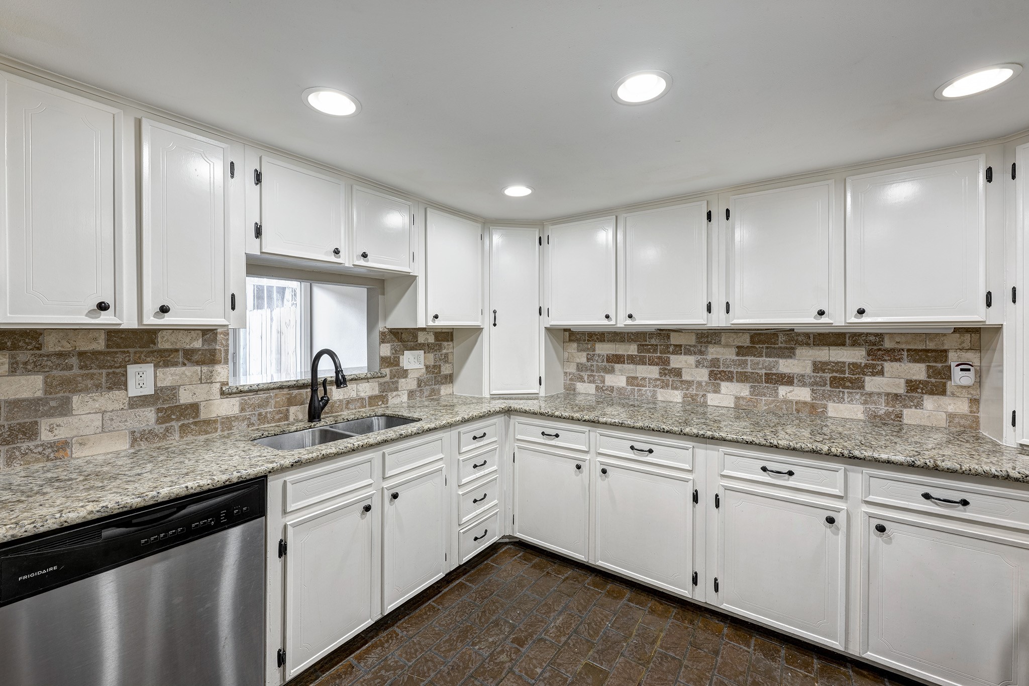 1122 Autrey Street, Unit 5 Houston, TX 77006 - Photo 6 of 32 Incredible amount of granite counterspace and cabinets in this kitchen. Pass thru above sink into dining room. Charming brick floors in kitchen also.