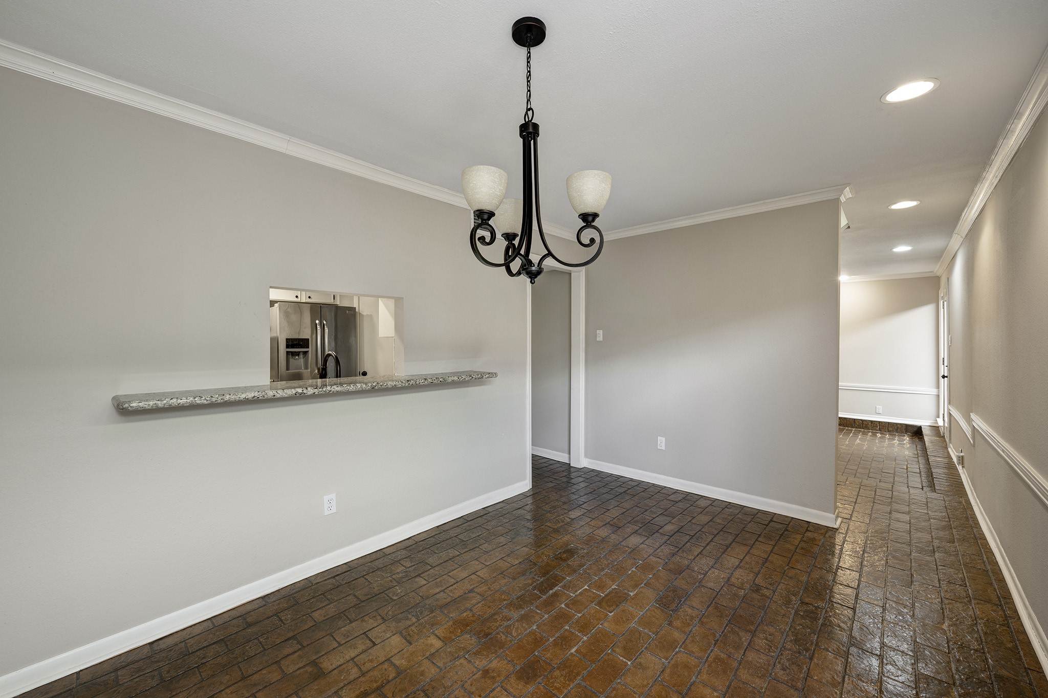 1122 Autrey Street, Unit 5 Houston, TX 77006 - Photo 9 of 32 Dining room looking to door into living room with access from kitchen thru door in the center and the pass thru with granite shelf. Beautiful brick floors.