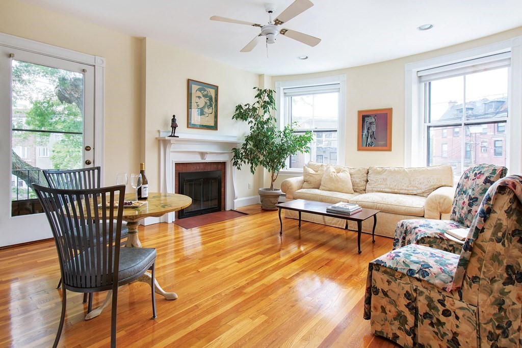 a living room with furniture a fireplace and a large window