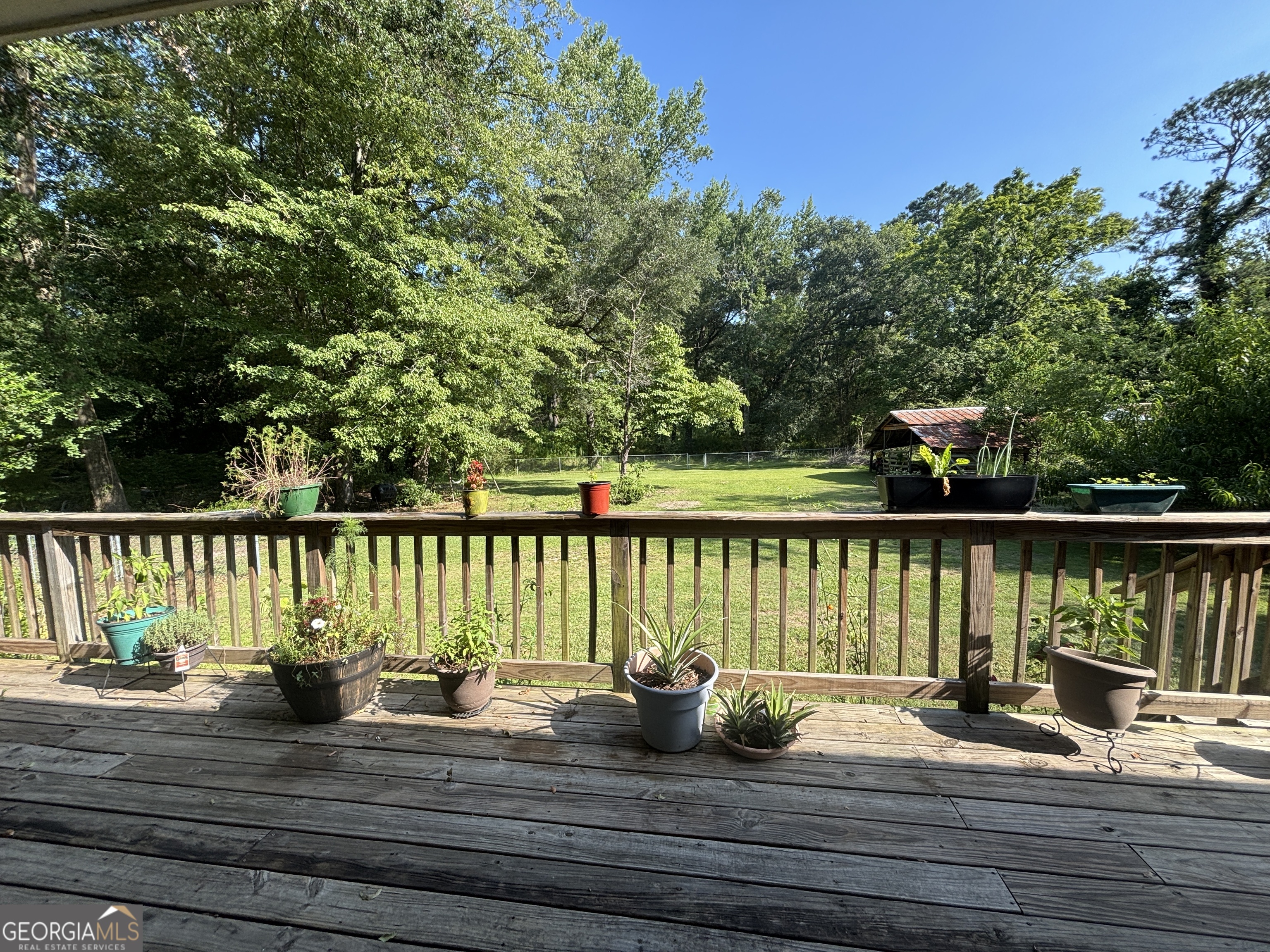 152 Crest Drive Cochran, GA 31014 - Photo 37 of 54 a view of a balcony with wooden chairs and floor to ceiling window