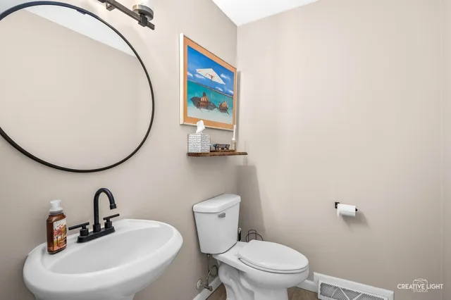 a bathroom with a toilet a sink and a mirror