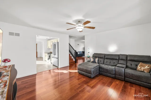 a living room with furniture and a wooden floor