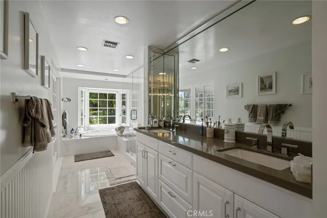 a bathroom with a granite countertop sink a mirror and a shower
