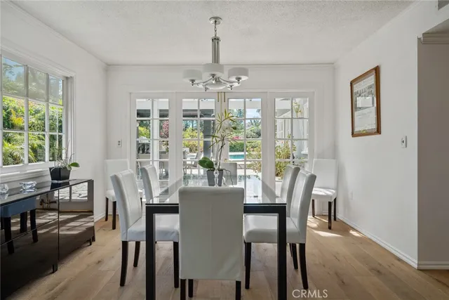 a view of a dining room with furniture a chandelier and wooden floor