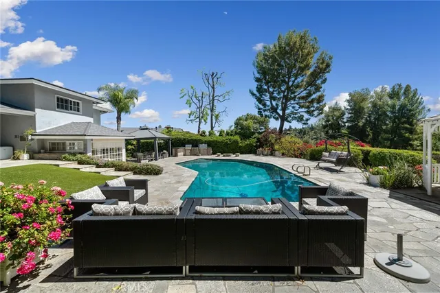 a view of a house with swimming pool and sitting area