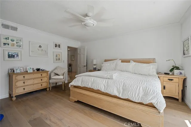 a spacious bedroom with a bed and a dresser