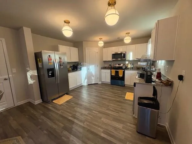 a kitchen with refrigerator and chairs