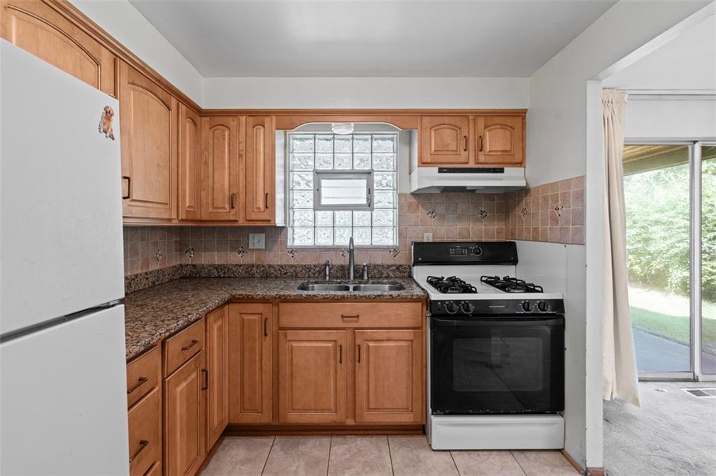 152 Malcolm Pittsburgh, PA 15214 - Photo 18 of 31 a kitchen with stainless steel appliances granite countertop a stove a sink and a microwave