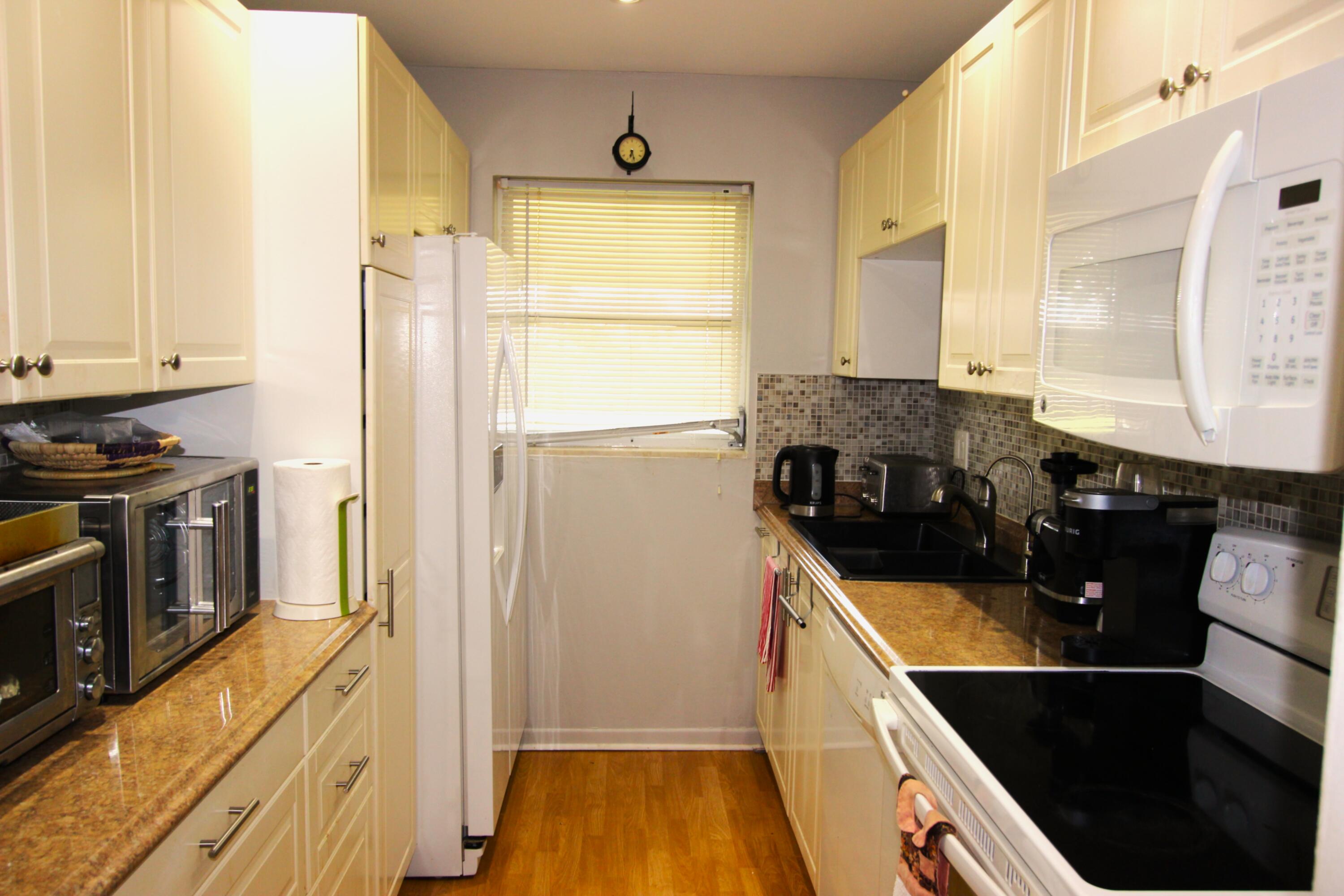 1045 East Circle Terrace, Unit B Delray Beach, FL 33445 - Photo 7 of 12 a kitchen with a sink a refrigerator and window