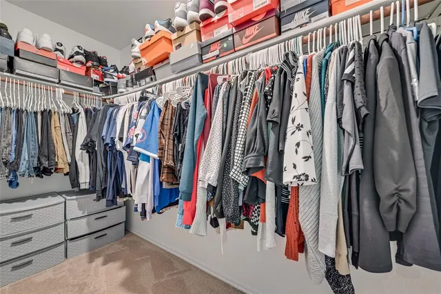 a view of walk in closet with clothes