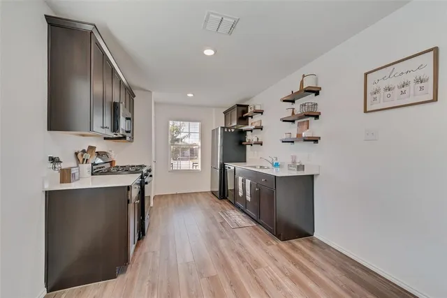 a kitchen with granite countertop a sink cabinets and wooden floor
