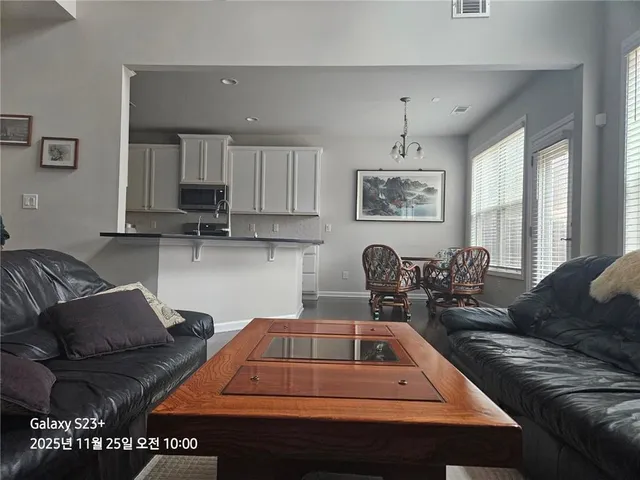 a living room with furniture and a chandelier