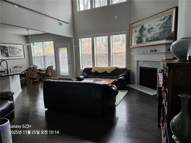 a living room with furniture large window and fireplace