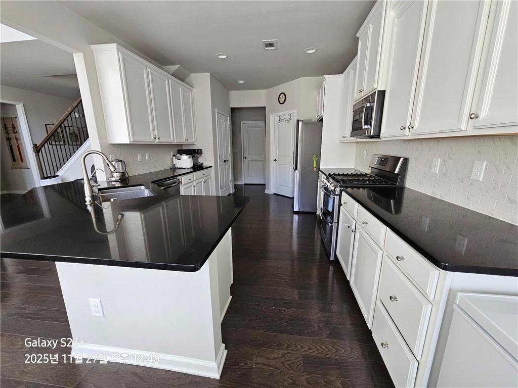 1909 Lakeview Bend Way Buford, GA 30519 - Photo 25 of 30 a large white kitchen with stainless steel appliances