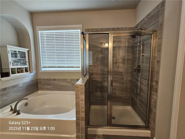 a bathroom with a shower and tub