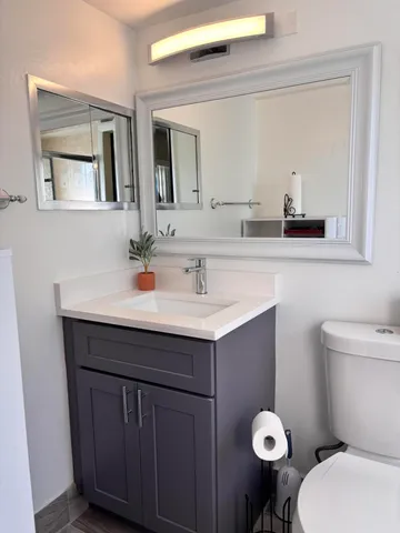 a bathroom with a sink mirror and toilet