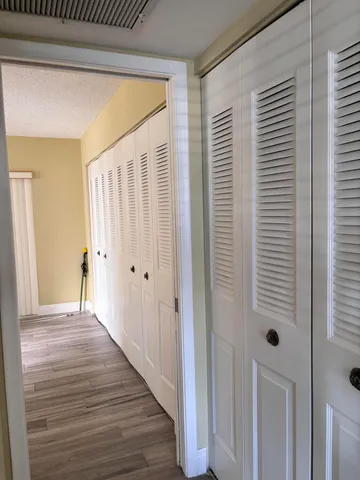 a view of a hallway with wooden floor and staircase