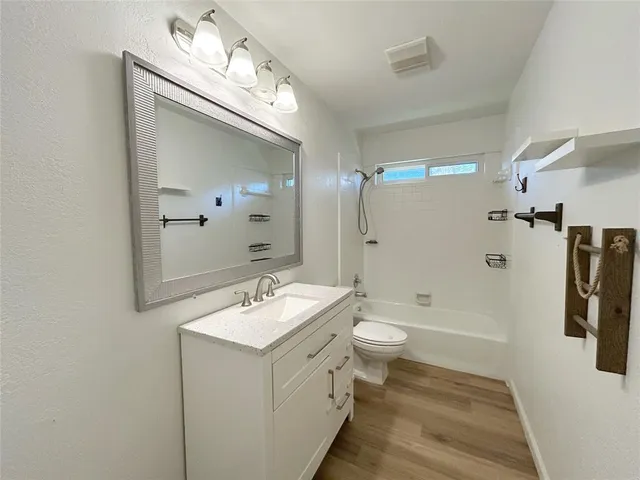 a bathroom with a double vanity sink a toilet a mirror and shower