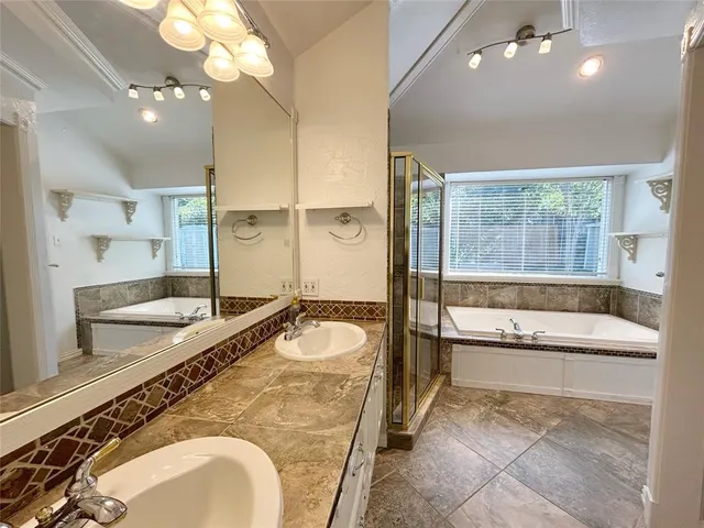 a spacious bathroom with a granite countertop tub sink and mirror