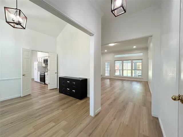 an empty room with wooden floor cabinet and windows