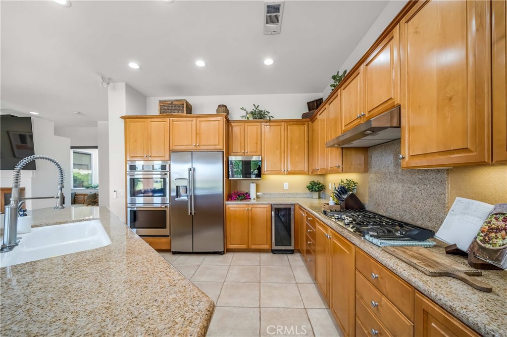 80305 Cedar Crest La Quinta, CA 92253 - Photo 11 of 26 a kitchen with stainless steel appliances granite countertop a stove a sink and a refrigerator