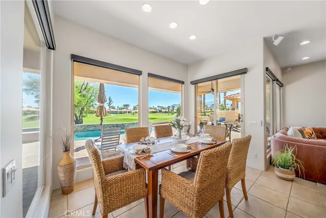 a dining room with furniture and large windows