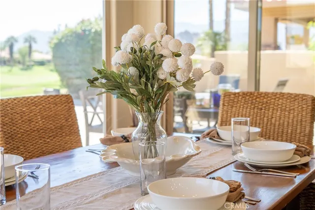 a dining room with furniture a rug and kitchen view