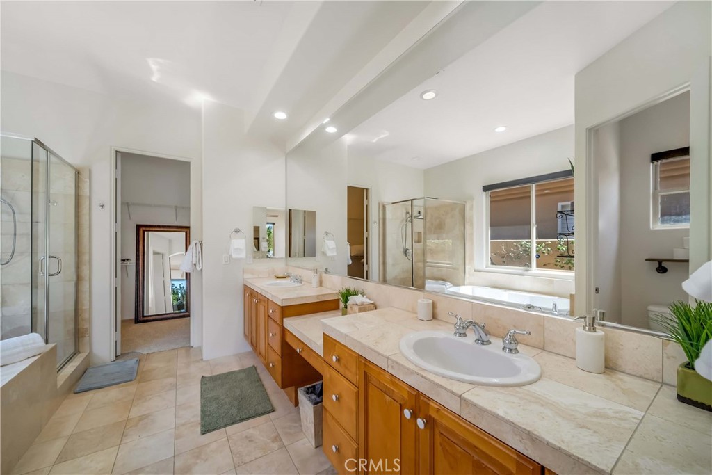 80305 Cedar Crest La Quinta, CA 92253 - Photo 22 of 26 a spacious bathroom with a granite countertop tub sink and mirror