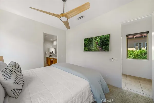 a bedroom with a bed and a night stand with potted plant