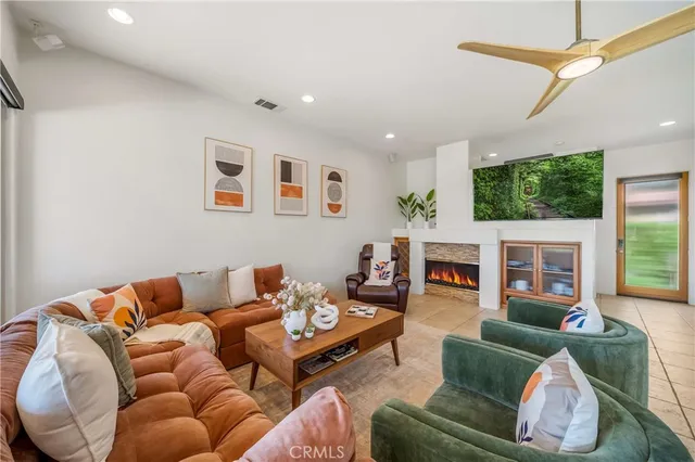 a living room with furniture a fireplace and a flat screen tv