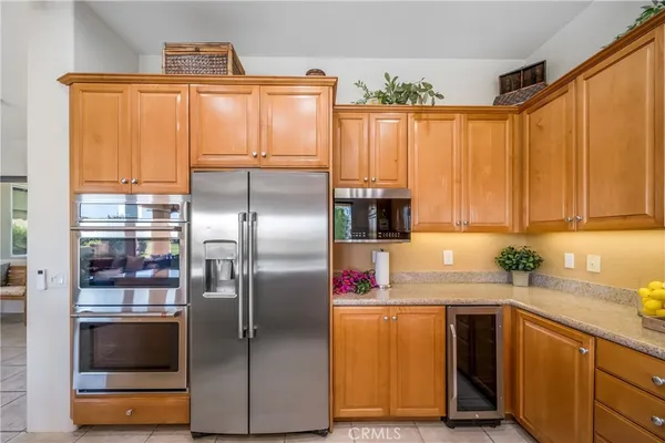 a kitchen with stainless steel appliances granite countertop a refrigerator a sink and a stove