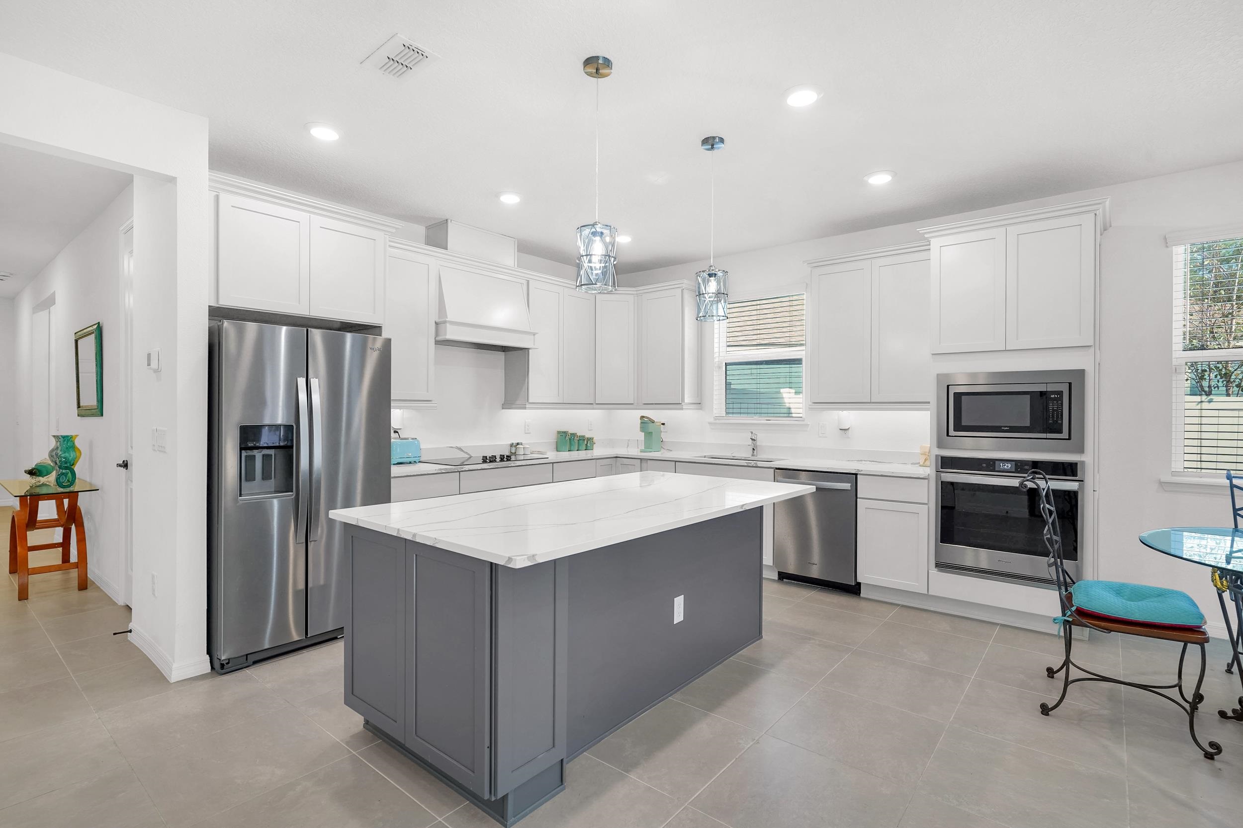 a kitchen with stainless steel appliances granite countertop a sink stove refrigerator and a refrigerator