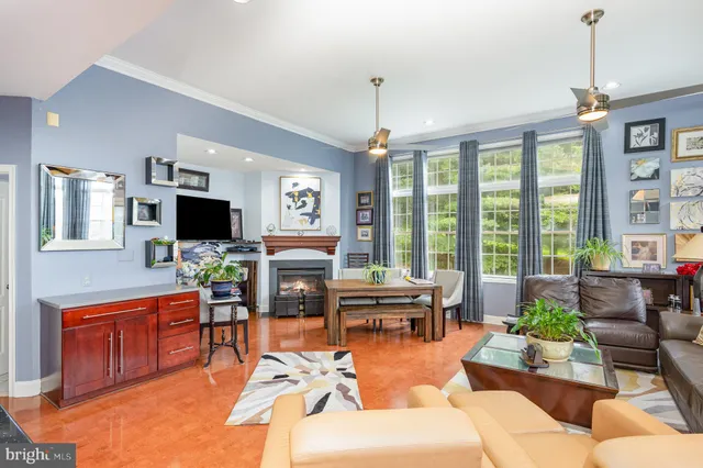 a living room with furniture a flat screen tv and a large window