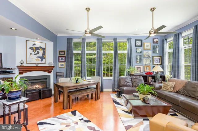 a living room with furniture a fireplace and a floor to ceiling window